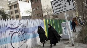 Iranian women walk past religious calligraphy in Arabic in central Tehran on Feb. 19, 2012. Escalating tensions between the West and Iran over the country's nuclear goals have caused concern for many security analysts.