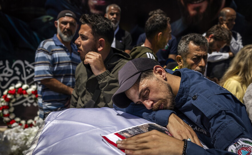 Hundreds of mourners march behind the coffins of three Lebanese Civil Defense paramedics on April 30, 2026, who were killed by Israeli strikes in southern Lebanon.
