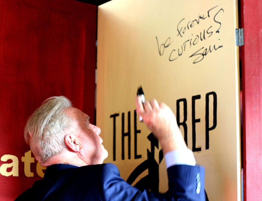 San Diego Repertory Theatre's outgoing artistic director, Sam Woodhouse, is shown in an undated photo writing "be forever curious" on a door.