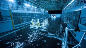 This Wednesday Feb. 19, 2014 photo released by NASA shows a test version of the Orion spacecraft, tethered inside the well deck of the USS San Diego prior to testing between NASA and the U.S. Navy.