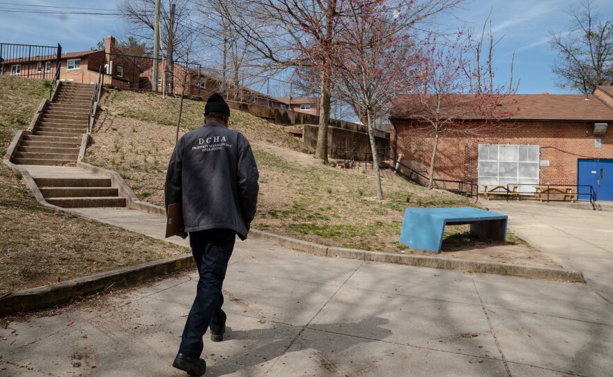 An employee of the District of Columbia Housing Authority walks on the grounds of a public housing complex called Richardson Dwellings in Northeast Washington, D.C. The Trump administration wants to eliminate the federal fund now used to repair public housing in favor of attracting more private investment to repair and replace it.