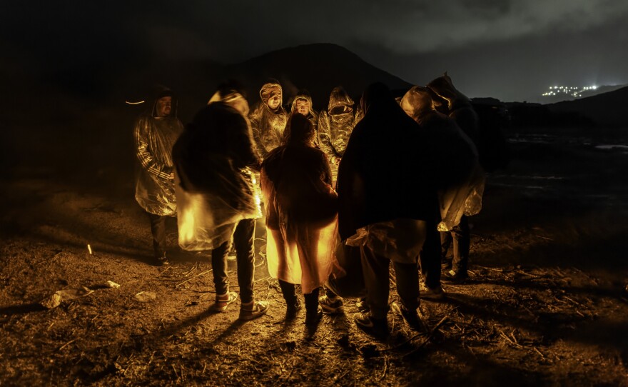 Immigrants from Ecuador warm themselves after crossing the U.S.-Mexico border on March 6, in Campo, Calif. Migrants from Ecuador, China, Georgia and other nations waited for U.S. Border Patrol agents to collect them to process asylum claims.