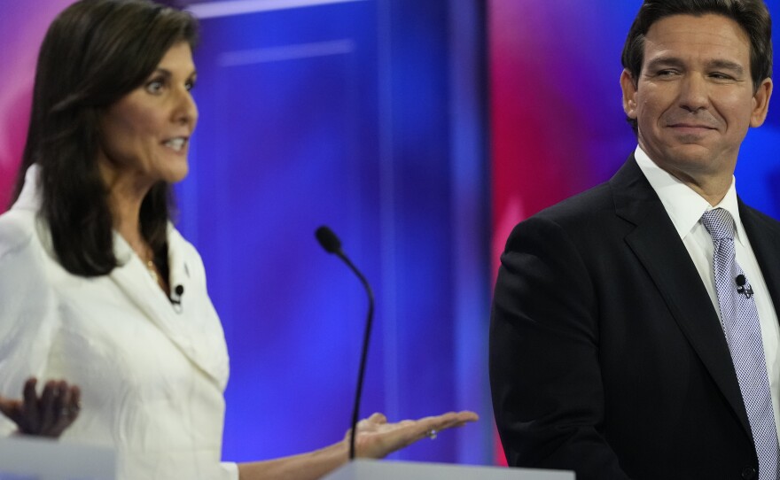 Republican presidential candidate former U.N. Ambassador Nikki Haley speaks as Florida Gov. Ron DeSantis listens during a Republican presidential primary debate hosted by NBC News on Wednesday in Miami.