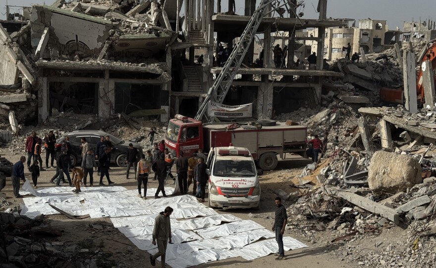 White body bags hold the remains of people recovered from the rubble of an apartment building destroyed by an Israeli strike.