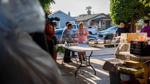 Shelltown neighbors gather for a hot meal at the home of Beba Zárate (left) on Wednesday, April 3, 2024. Donations to be distributed to flood survivors pack her carport.
