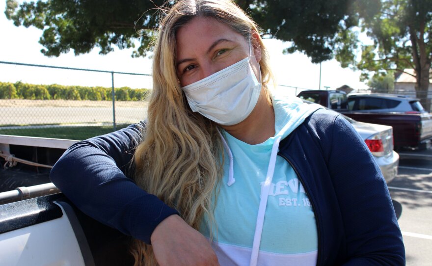 Farmworker Alejandra Beltran, 44, leans on her truck near vineyards in Biola, California, on Oct. 13, 2021. Beltran said she worked outdoors in heavy smoke conditions as recently as Oct. 4 and 5, but wasn’t aware of the required worker protections.