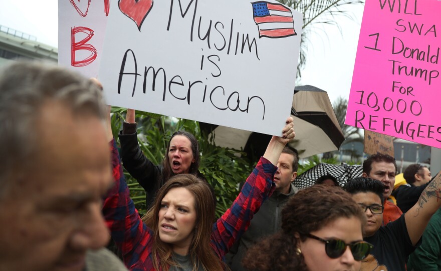Tristan Houghton (second from left) joins with other demonstrators as they protest the president's executive order at the Miami International Airport on Sunday.