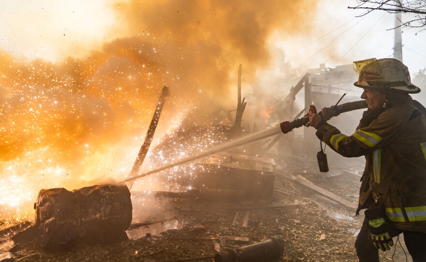 A rescue worker puts out a fire at residential houses destroyed in a Russian strike on Kharkiv, Ukraine, Sunday, Oct. 11, 2026.