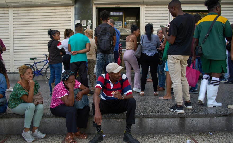 People wait their turn to enter a bank in Havana, Cuba, Wednesday, April 1, 2026.