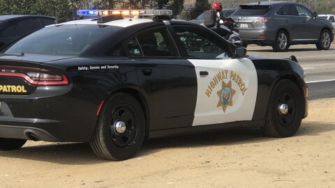 A CHP car is pulled over on the side of the freeway in Carlsbad, Nov. 19, 2021.