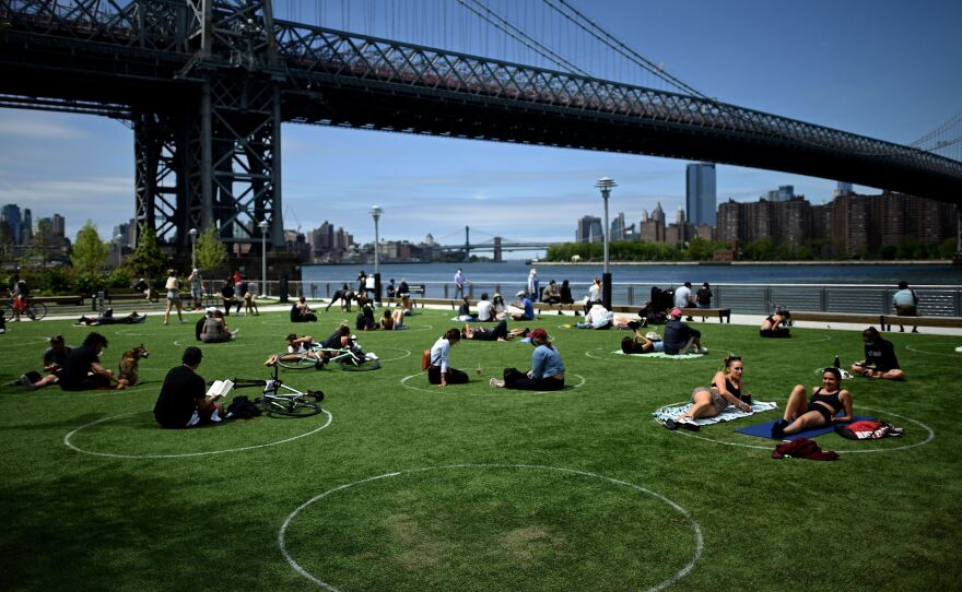 A new study has found that parks in low-income and majority nonwhite communities are smaller and serve a larger number of people per park acre. People are seen here relaxing in May in Brooklyn's Domino Park.