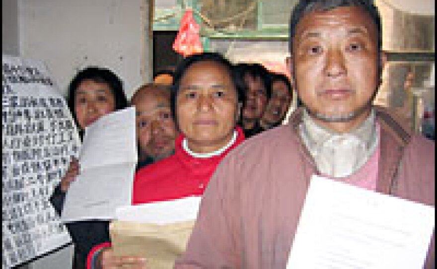Petitioner Wu Zhiyin, a farmer from eastern Jiangsu province, with other out-of-towners seeking justice in Beijing. They've traveled to Beijing by bus, train and on foot, bearing stacks of documents related to their cases.