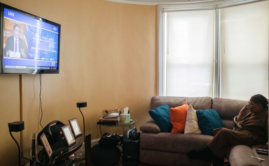 Raymonde Elian watches the daily coronavirus briefing from New York Gov. Andrew Cuomo on her day off from work in April. Despite the stress of work, she wanted to make sure she was getting the latest updates for perspective on what she was seeing at the hospital.