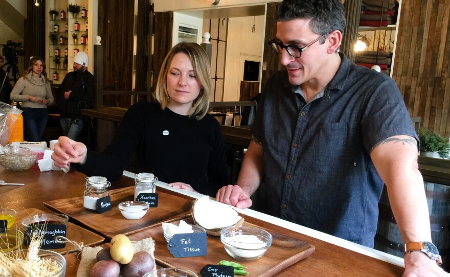 Ashley Kleckner of Impossible Foods demonstrates to chef Brad Farmerie how the Impossible Burger is assembled.