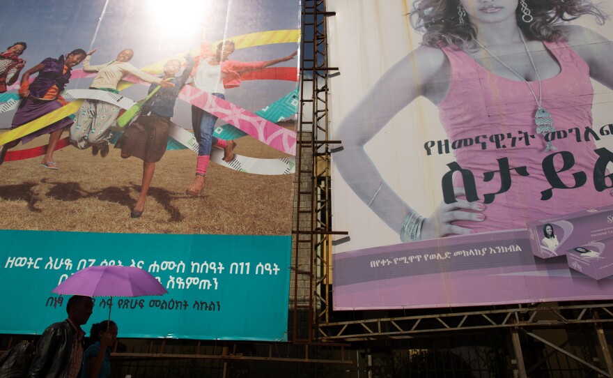 A couple walks by billboards advertising family planning methods in Addis Ababa.