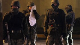 Members of the Mexican Army study a map at an early morning murder, one of numerous murders over a 24 hour period, on March 26, 2010 in Juarez, Mexico.