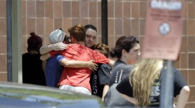 People react outside the unification center at the Alamo Gym, following a shooting at Santa Fe High School in Santa Fe, Texas. Friday, May 18, 2018. 