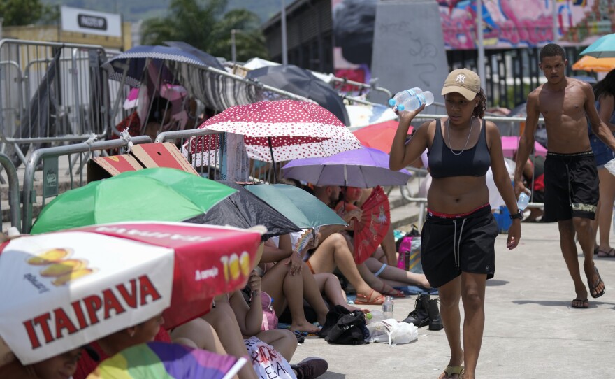 Street vendors sell bottled water to Taylor Swift fans amid a heat wave before her Eras Tour concert outside the Nilton Santos Olympic stadium in Rio de Janeiro, Brazil, Saturday, Nov. 18, 2023.