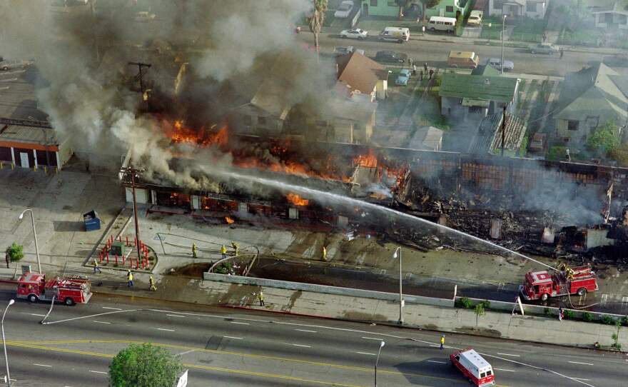 Firefighters extinguish a fire during the rioting in Los Angeles, on April 30, 1992.