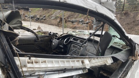 A car that had been swept away in the flooding but was now sitting in a parking lot beside Chollas Creek on Feb. 1, 2024.