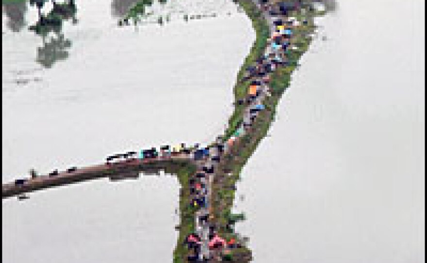 This aerial view shows Indian villagers displaced by floods taking refuge on the raised surface of the road in the Darbhanga district of the Indian state of Bihar. Rescue operations were underway as the number of people stranded by floods from torrential monsoon rains and glacial snowmelt climbed to 12 million across north India, officials said.