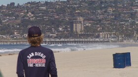 A city of San Diego lifeguard stands on Mission Beach, March 24, 2020.
