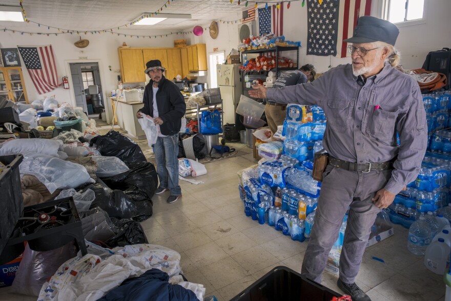 Sam Schultz points out the piles of clothes, food and water that will be donated to migrants in Jacumba Hot Springs, Nov. 15, 2023.