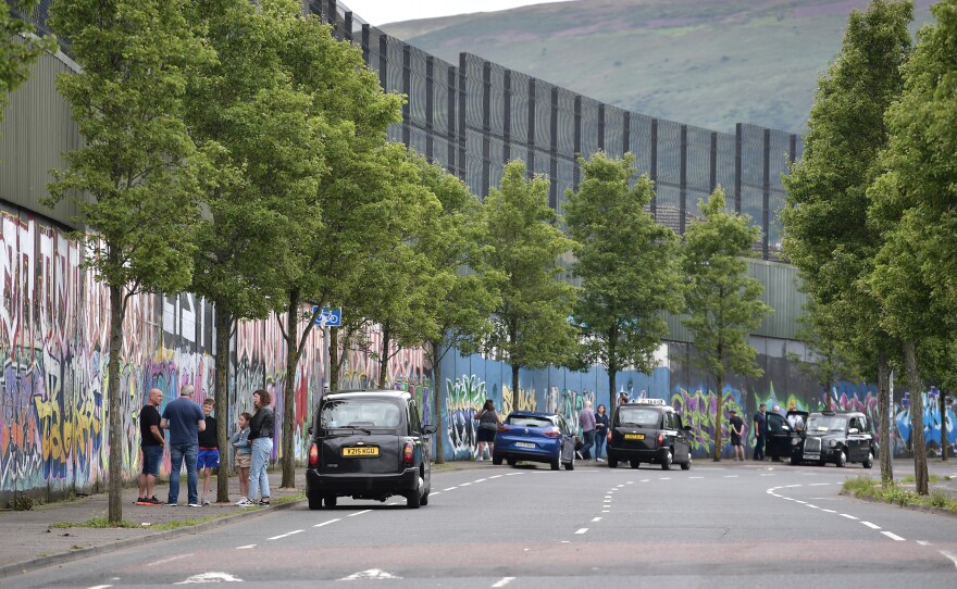 Tourists are given black taxi tours along the peace wall on Cupar Way in Belfast.