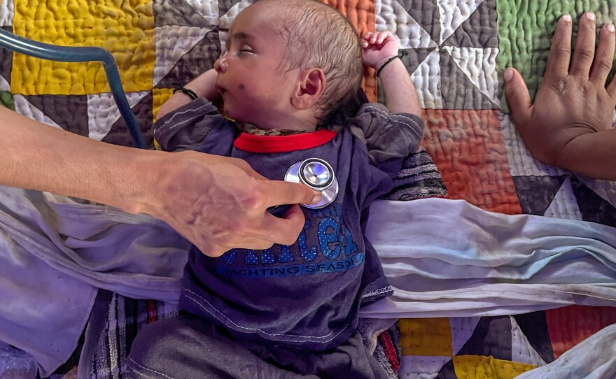 Mankani checks the vital signs of a newborn baby. The mother was worried that he was not getting enough food. A minute later, there were sighs of relief all around as Mankani told the mother that her baby was doing just fine.