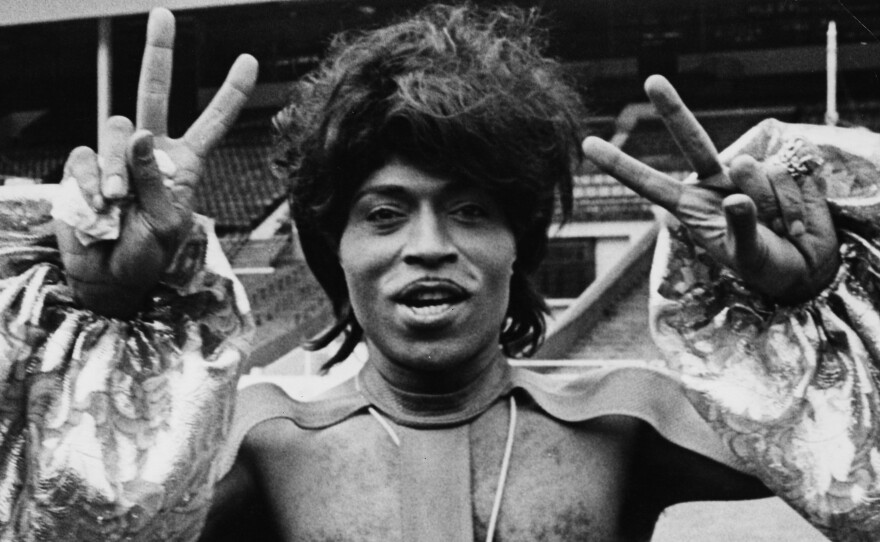 Singer Little Richard making peace sign and wearing an outlandish outfit as he prepares to perform at Wembley Stadium, 1972. (Photo by Rosemary Matthews/Keystone Features/Getty Images)