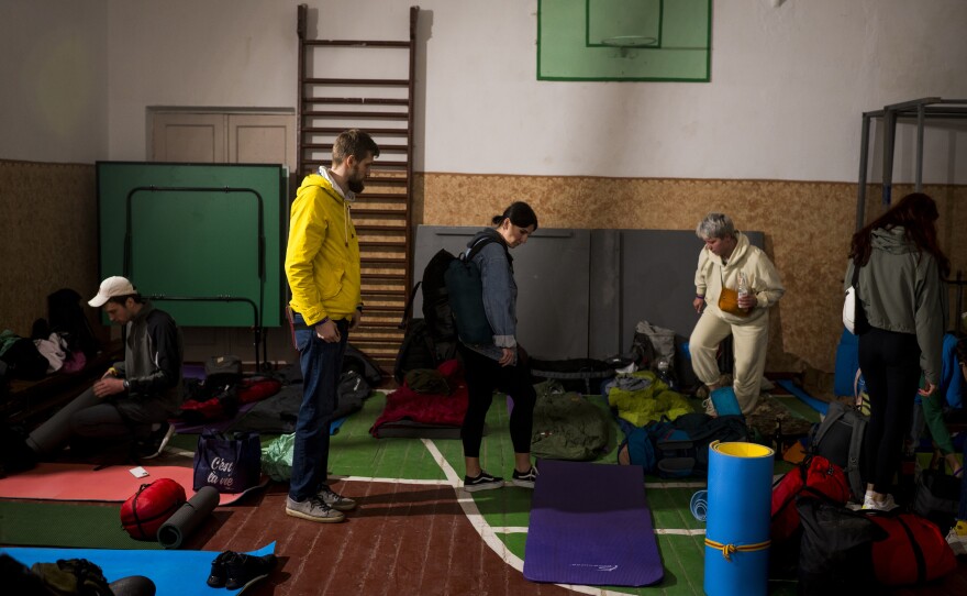 Volunteers put down sleeping pads in a school gym where they will sleep for the night in Anysiv, Ukraine, on Oct. 1.