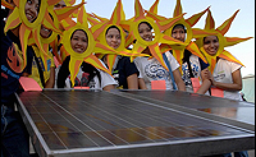 People who want to counterbalance the amount of carbon they emit are buying "carbon offsets." These offsets are used by companies to invest in renewable energy sources, such as solar. Here, solar advocates in Manila participate in a recent parade calling on the government to support more renewable energy.