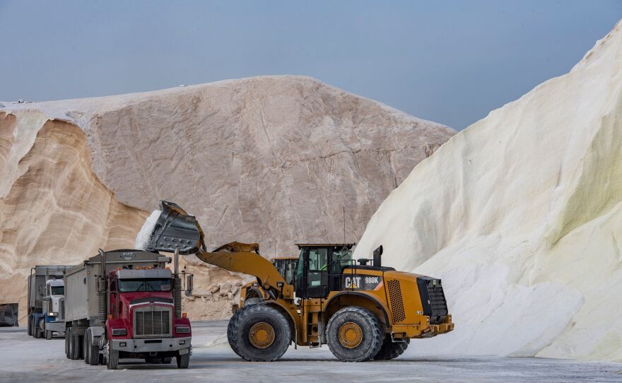 A bulldozer loads trucks with salt at Eastern Salt in Chelsea, Mass., on Friday. The salt company serves dozens of towns and cities in Massachusetts and the salt will be used to treat roads and highways as the winter storm approaches.