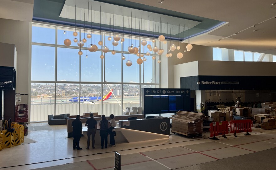 A plane passes by on the runway, seen through the windows at San Diego International Airport's New Terminal 1, Aug. 27, 2025.