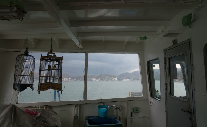 Songbirds chirp in their cages as a storm moves toward the ferry.