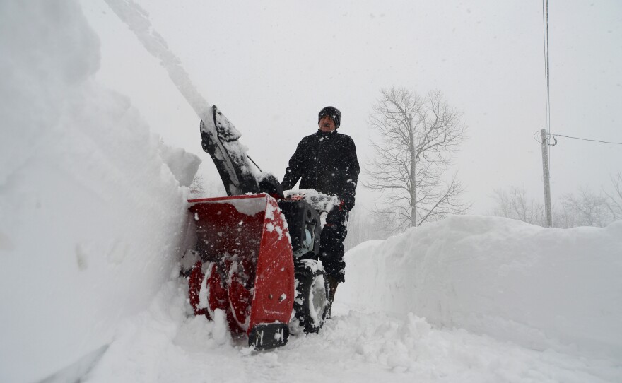 Denis Marszalkowski uses a snowblower to dig out after an intense lake-effect snowstorm hit Western New York.