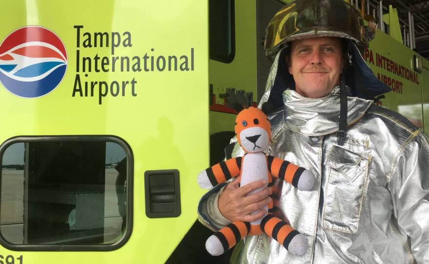Hobbes poses for a photo with a member of the airport's tarmac emergency crew. The tiger was safely reunited with his young owner — along with a photo album of his exploits.