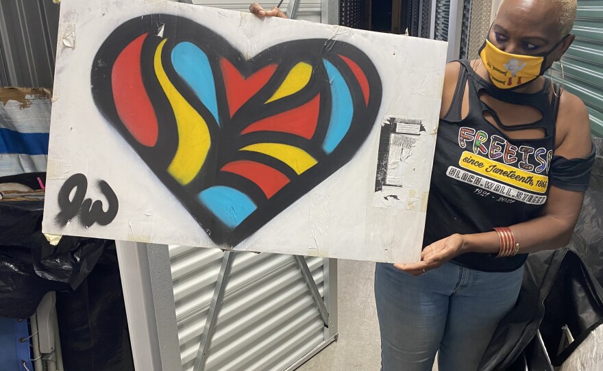 Nadine Seiler poses with a piece of artwork that was once displayed on the Black Lives Matter fence near the White House. Seiler is working to find new homes for the 700-plus artifacts left by protesters.