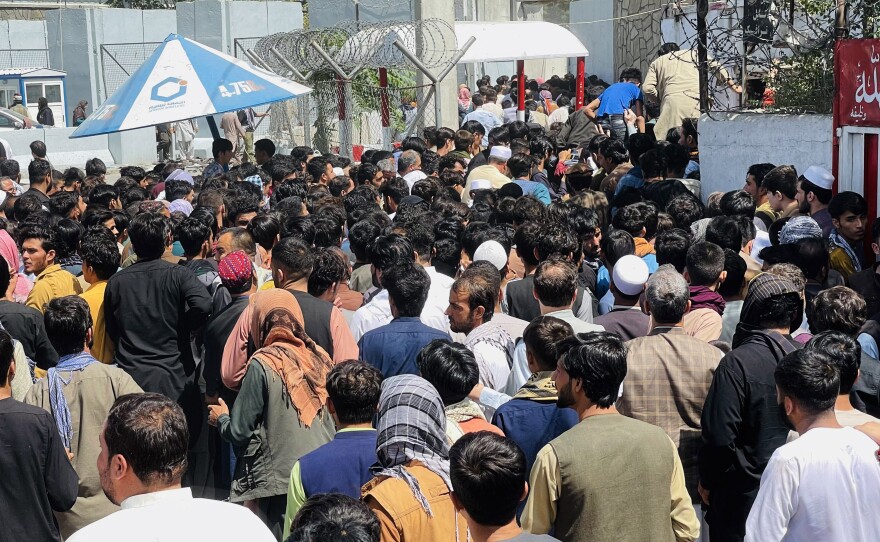 Afghans rush to the Hamid Karzai International Airport as they try to flee the Taliban takeover of Kabul.