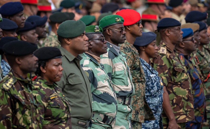 Commonwealth troops wait on Thursday to receive commemorative coins during a military parade in Pirbright, England, for representatives of the Commonwealth taking part in the coronation of King Charles III.