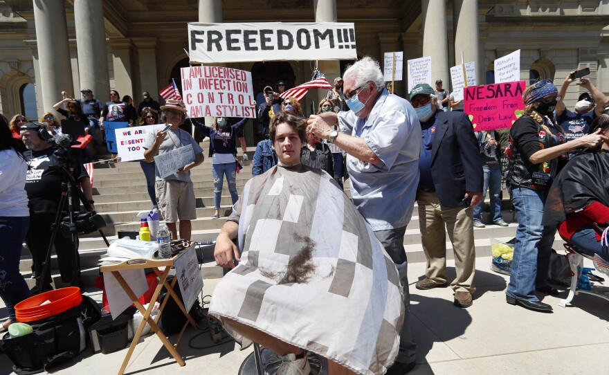 Barber Karl Manke, of Owosso, Mich., gives a free haircut to Parker Shonts on May 20 on the steps of the State Capitol. On Thursday, the Michigan Court of Appeals says Manke must close his barbershop.