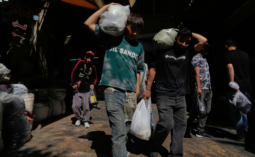 People carry packages at Tehran's historic Grand Bazaar, Iran, Monday, June 1, 2026.