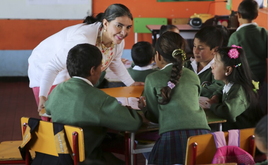 Teacher Maria Isabel Camango Guido instructs a group of students. Concepts from different subjects are combined in each lesson, into a simplified version of project-based learning.