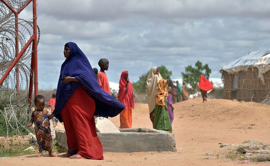 A refugee stands with her son just outside a fenced perimeter at the sprawling Dadaab refugee camp in May 2015.