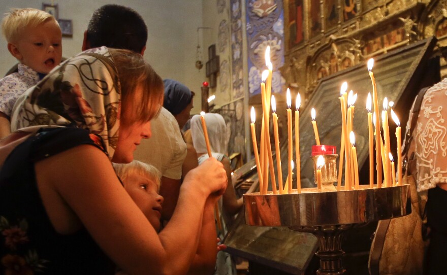 Three days after the Bastille Day attack, people light candles during a mass at Nice's Saint Nicolas Orthodox Cathedral.