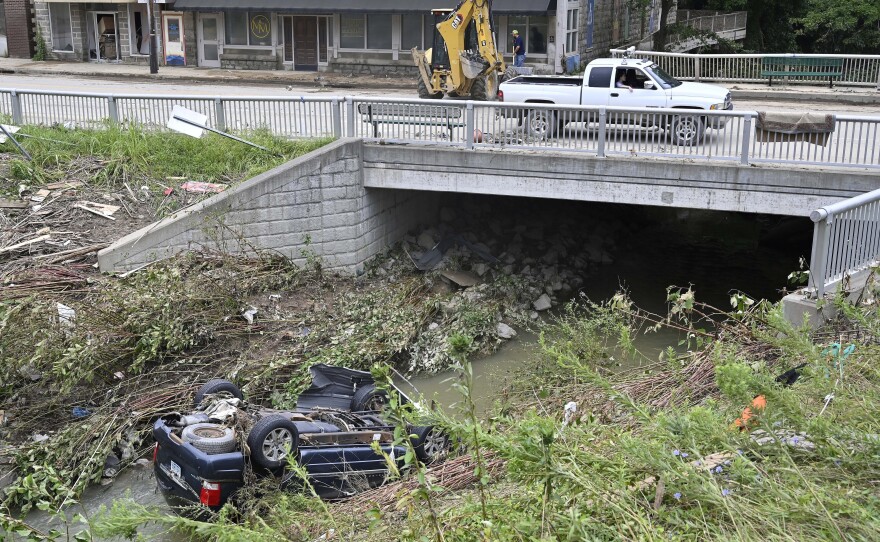 A car lays overturned in Troublesome Creek in downtown Hindman, Ky., on Sunday.