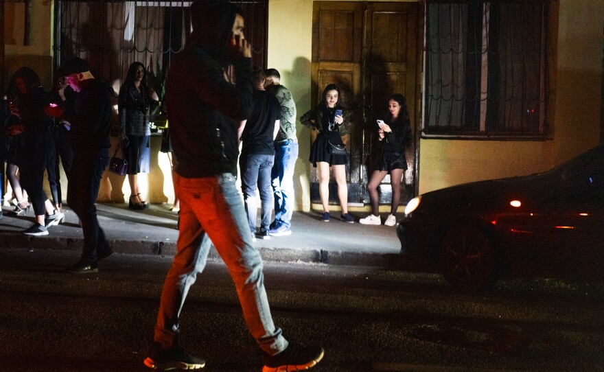 Just after 11 p.m., people leave the club when police arrived, standing outside and waiting to see if the party will continue.
