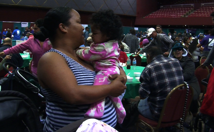 Homeless mother Janelle is pictured holding one of her two children at San Diego Homeless Connect in downtown's Golden Hall on Jan. 28, 2015.