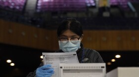 San Francisco Department of Elections worker Rosy Chan checks for damaged ballots at a voting center in San Francisco, Sunday, Nov. 1, 2020.