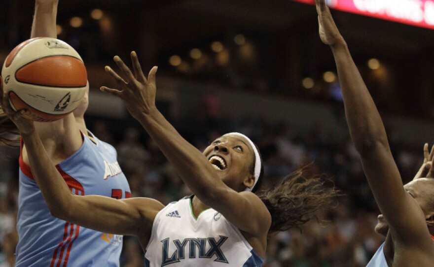 <p>Minnesota Lynx guard Candice Wiggins (center) goes up for a shot against Atlanta Dream center Alison Bales (left) and forward Sancho Lyttle in the second half of Game 1 of the WNBA finals basketball series on Sunday.</p>